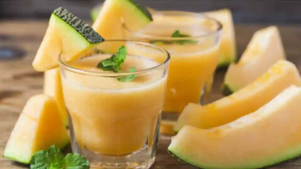 Fresh muskmelon juice in glass with slices, healthy summer drink